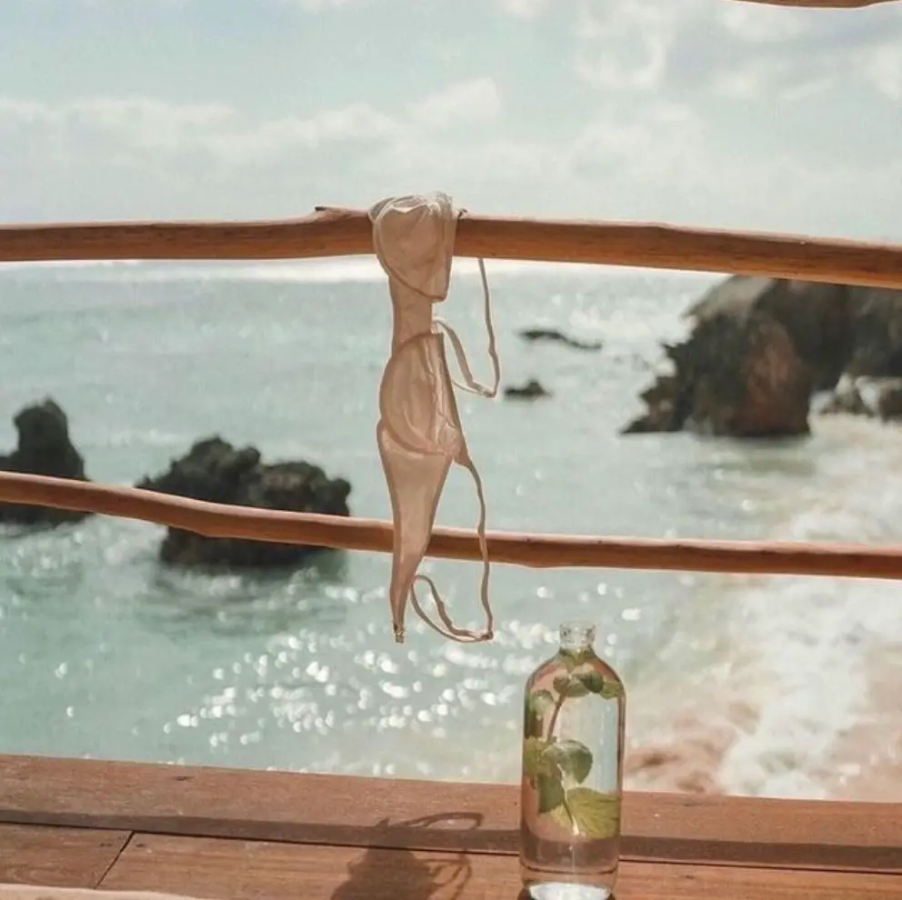 Delicate silver jewellery styled with swimwear by the ocean